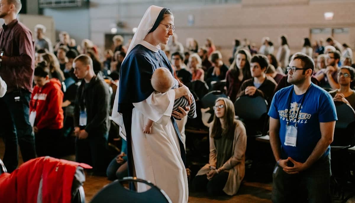 Una monja de Sisters of Life durmiendo a un niño durante un congreso de FOCUS