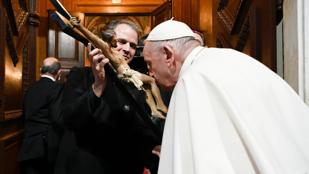 Francisco besa la cruz al inicio del encuentro con la comunidad católica de Grecia