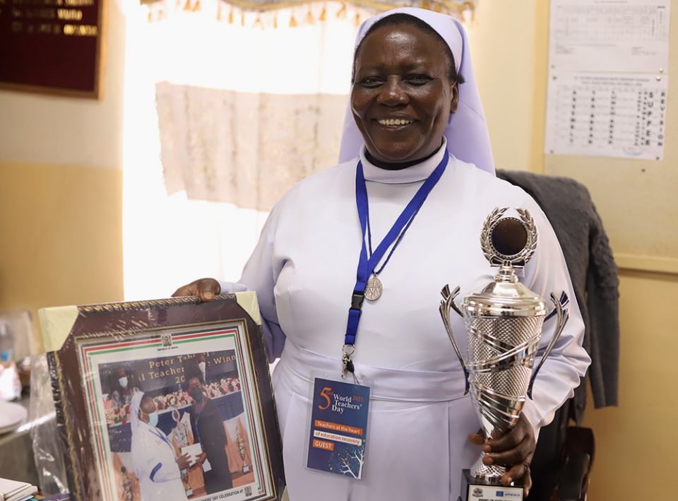 La hermana Anne Onyancha sosteniendo el premio al mejor profesor. 