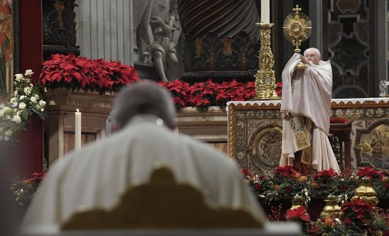 El cardenal Re bendice con el Santísimo.