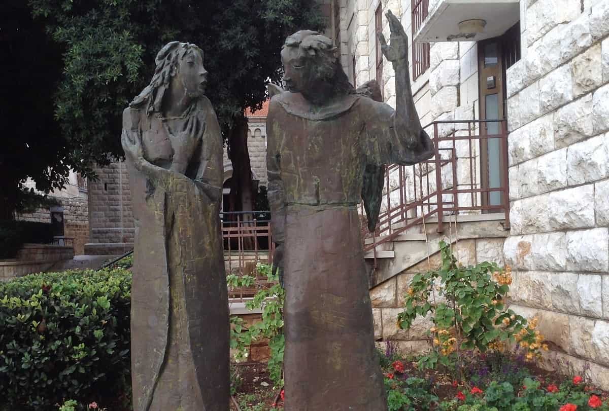 Estatua de la Anunciación de un autor nigeriano, con la iglesia de San José al fondo, en Nazaret