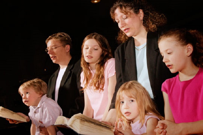 Papá, mamá y cuatro hijos en misa - las familias más practicantes son las que tienen, por estadística, más hijos