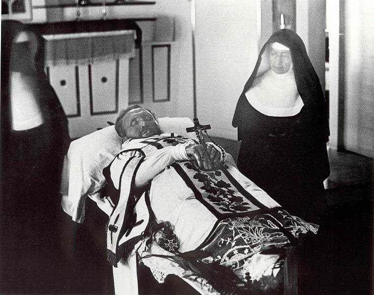 Santa Marianne Cope junto al cadáver de San Damián de Molokai en 1889