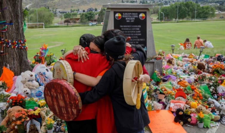 Indígenas en un memorial en 2021 por los niños muertos en Kamloops 