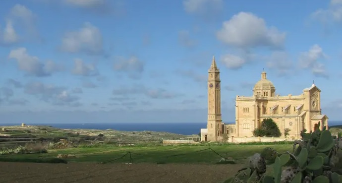 Santuario mariano de Ta Pinu en Gozo, Malta, rodeado de campos y con el mar de fondo