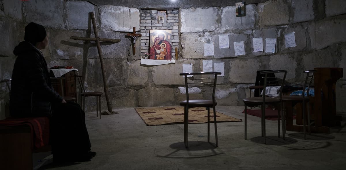 Una religiosa reza en una capilla improvisada en un sótano en Ucrania en previsión de bombardeos