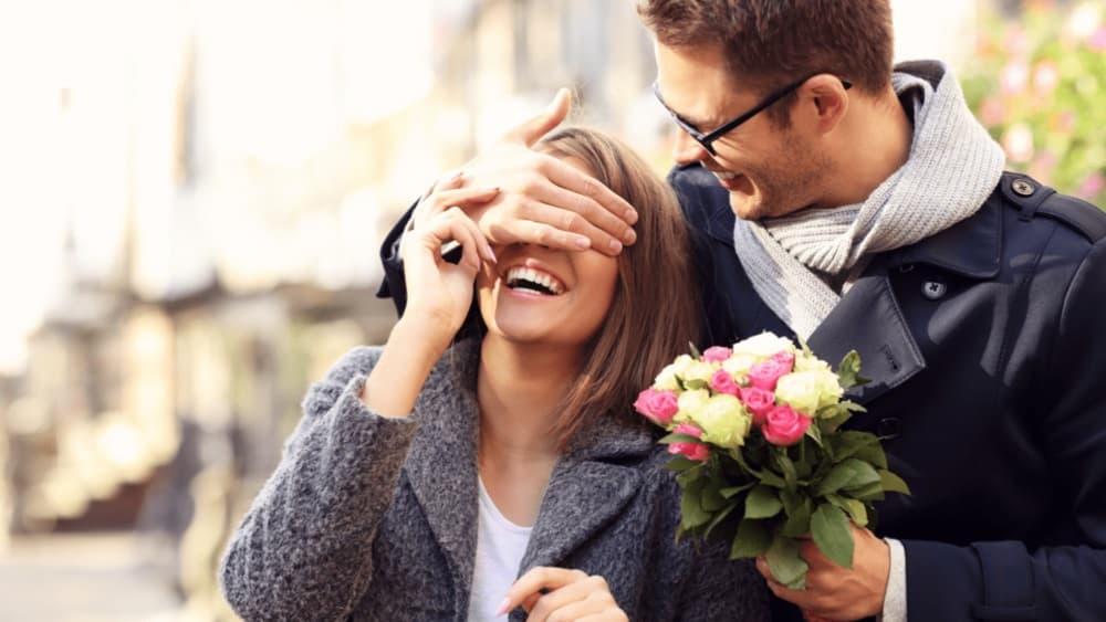 Hombre regala flores a su mujer.