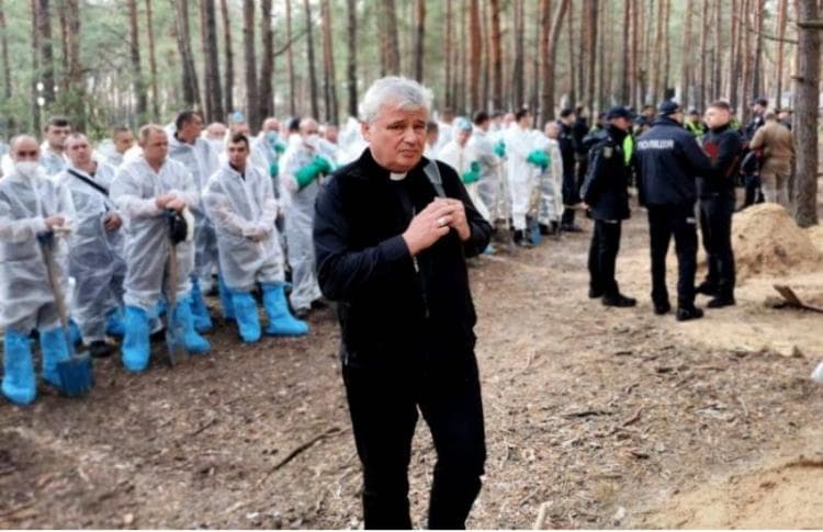 El cardenal Krajewski. emocionado, con los trabajadores que exhuman los cuerpos hallados en Izium