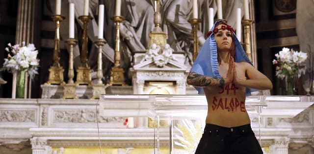 Activista de Femen desnuda de cintura para arriba en la iglesia de la Madeleine en 2013 en París