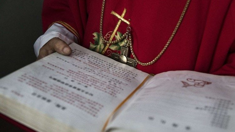Un misal en chino en manos de un eclesiástico