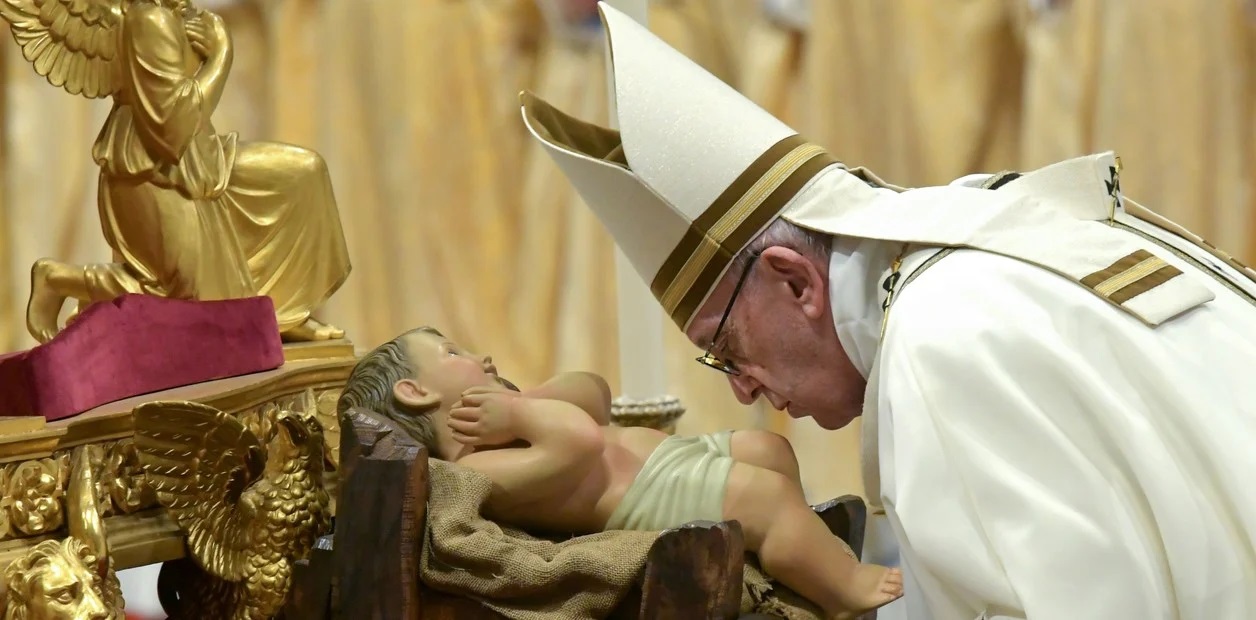 Papa Francisco, en la misa de Gallo, besando al Niño Jesús.