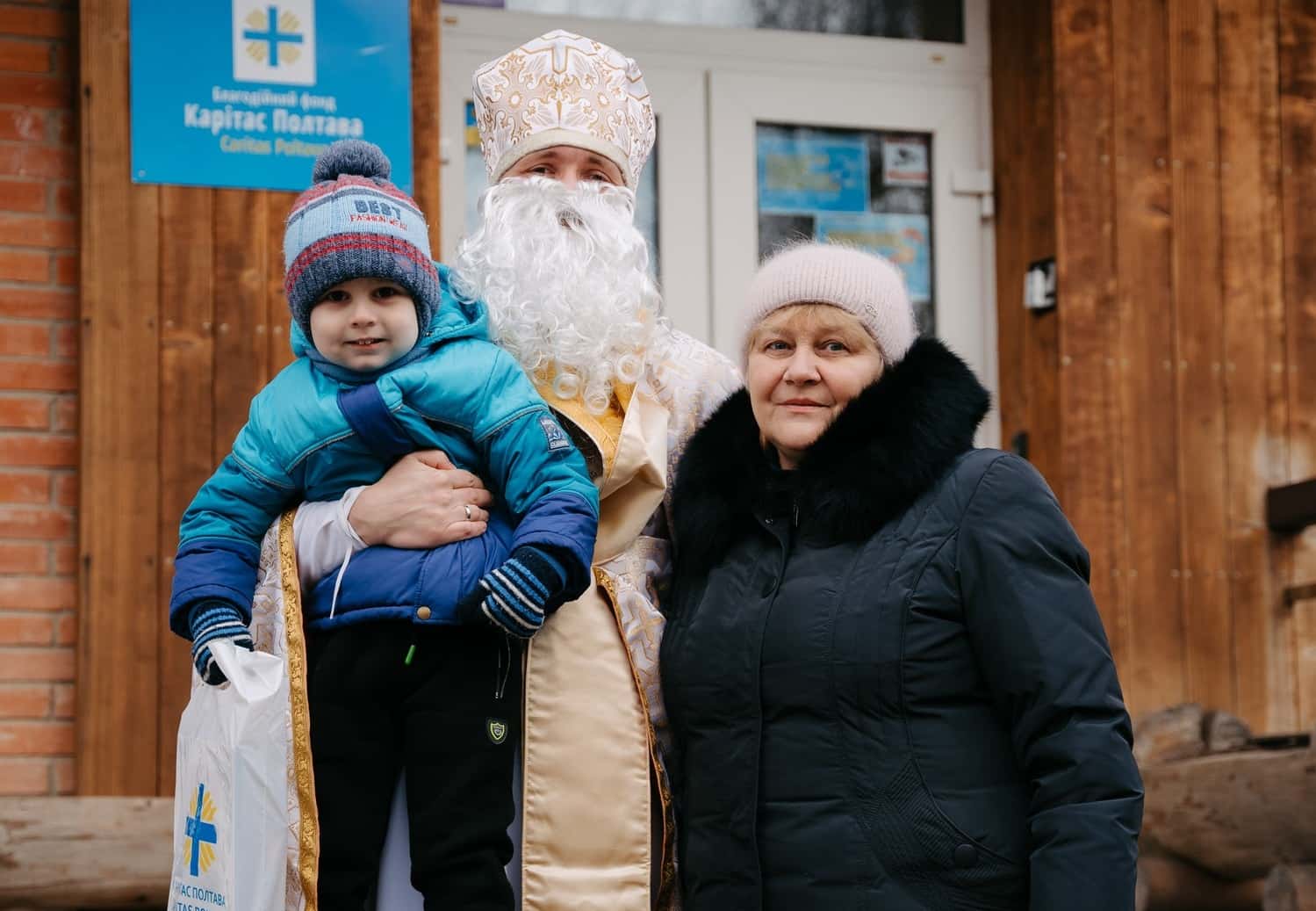 San Nicolás, vestido de obispo oriental, lleva regalos a la puerta de Cáritas Poltava