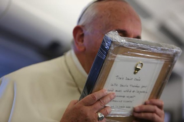 El Papa Francisco en el avión de Filipinas con el relieve de Teresita que le dio una periodista de Paris Match
