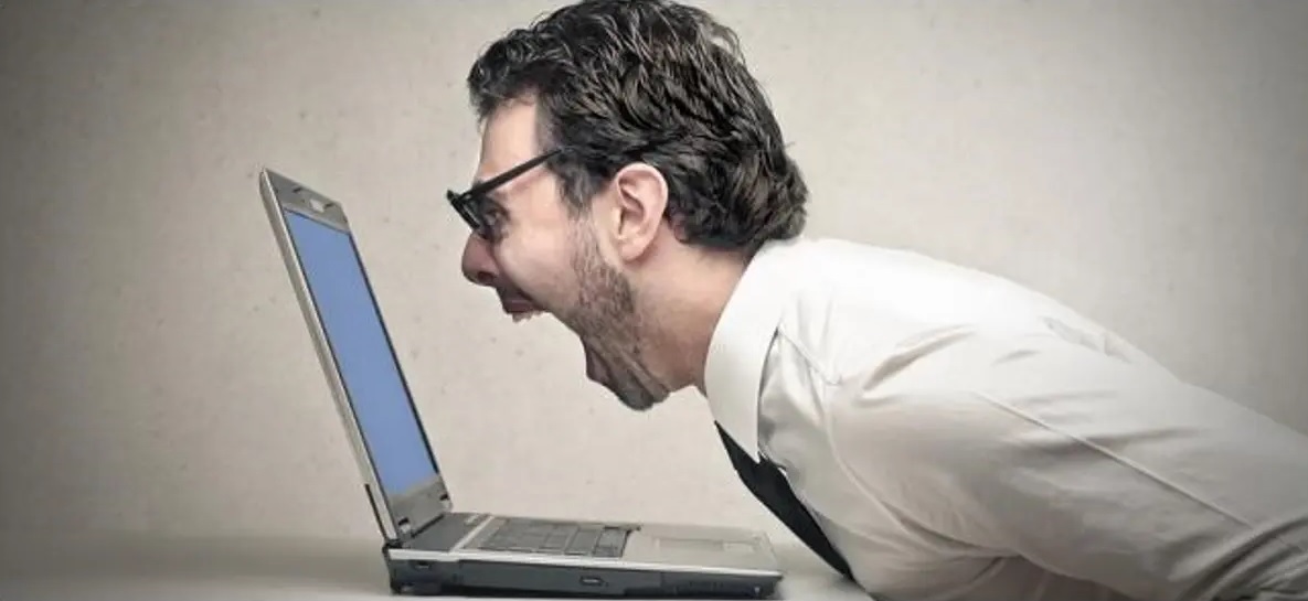 Hombre gritando al ordenador. 