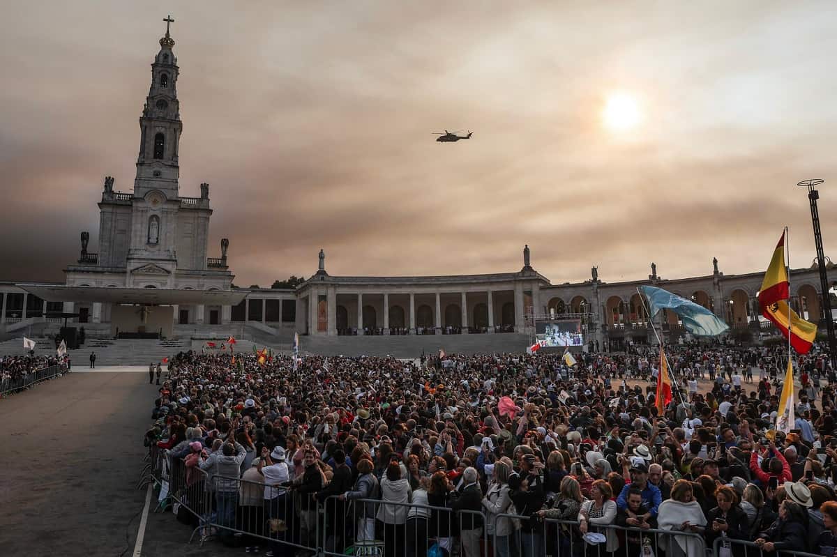 El helicóptero del Papa y la gente que espera en Fátima, en un cielo manchado por los incendios cercanos