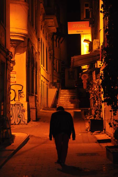 Un hombre camina solo por la calle solitaria, de noche.