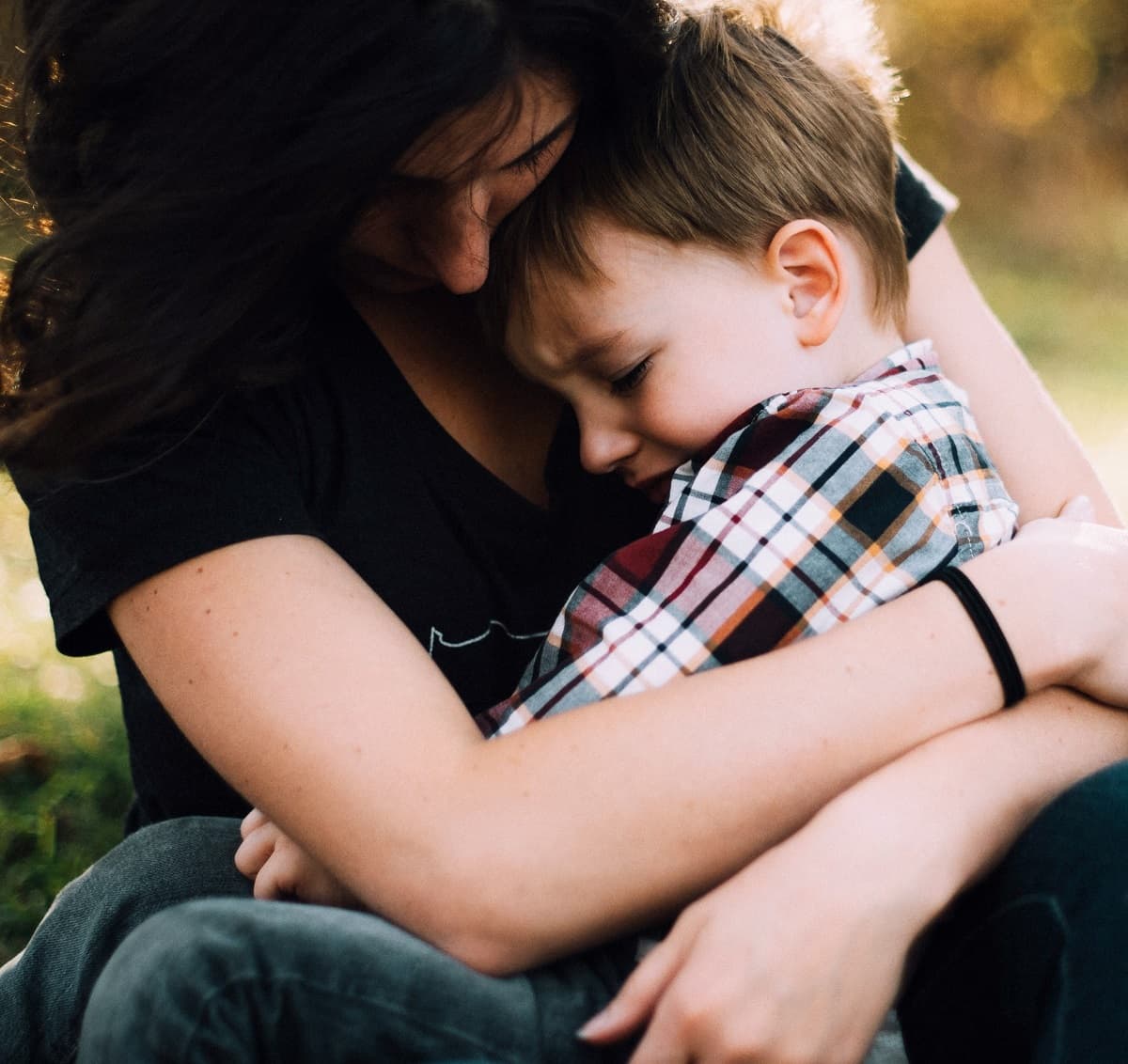 Una madre consuela con un abrazo a hijo pequeño  en una foto de Jordan Whitt en Unsplash 
