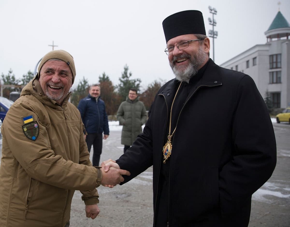 El diácono Tokach, de camuflaje, con el arzobispo mayor grecocatólico, Shevchuk, al entregar su ambulancia número cien