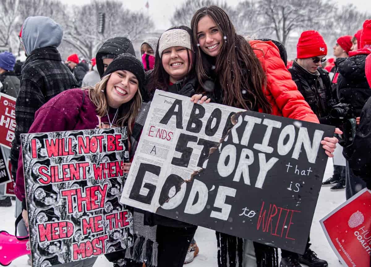 Mujeres jóvenes provida sonrientes con carteles en la Marcha por la Vida 2024 de Washington