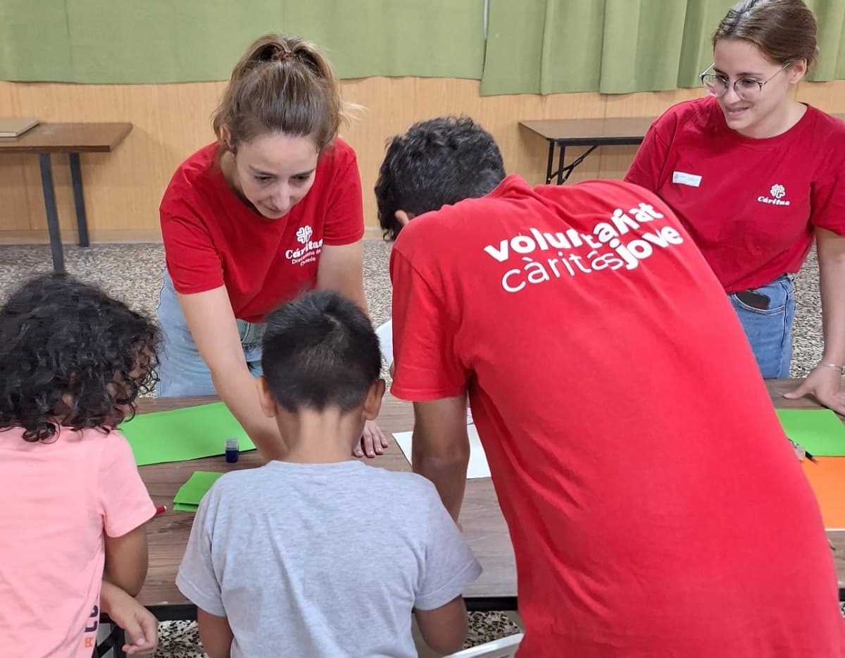 Voluntarios jóvenes de Cáritas en España juegan con niños 