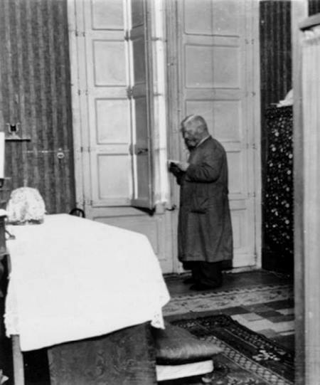 Ataviado con un guardapolvo y con barba crecida, el obispo Irurita reza el breviario en su escondite en casa de los Tort, donde se improvisó un altar para las misas.
