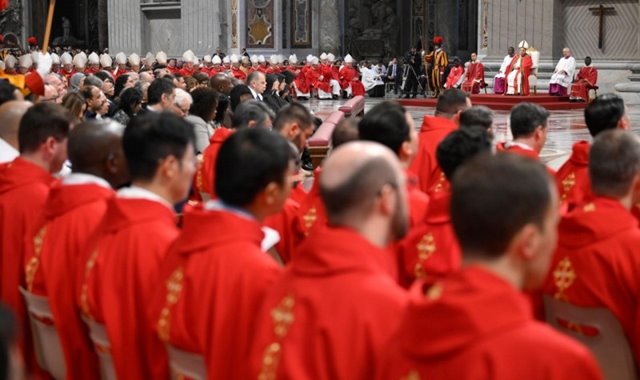 Cardenales, obispos y sacerdotes con las vestiduras rojas que corresponden a la liturgia de Pentecostés.