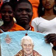Un camerunés sostiene un cartel del Papa
