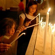 Niños rezan con velas