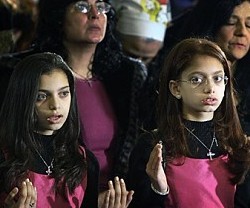 Unas niñas egipcias, cristianas coptas, rezan el Padrenuestro