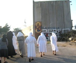 Unas religiosas católicas pasan junto al muro que tiene encajonados a los habitantes de Belén