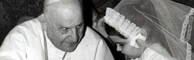 Juan XXIII reza con una niña enferma, en una de sus imágenes más recordadas