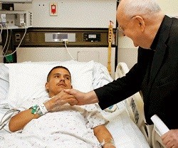 Un sacerdote atiende a un enfermo