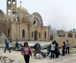 Cristianos greco-ortodoxos se acercan a lo que queda de su parroquia de San Elías en Qusayr, Homs