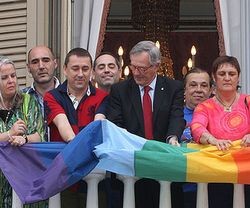 El alcalde de Barcelona, Xavier Trias, de CiU, despliega una bandera gay en el balcón del Ayuntamiento, con líderes del lobby gay de Cataluña