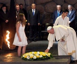 Francisco y dos jóvenes católicos vestidos de blanco ofrecen unas flores en la Sala Memorial de Yad Vashem