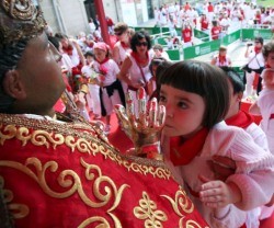 Una niña va a a besar la imagen del popular San Fermín, que fue obispo de Pamplona y un predicador viajero e incansable