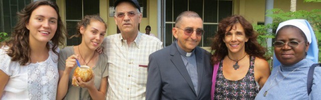 El padre Aldo Marchesini, vetsido con clérguiman y acompañado de unos colaboradores