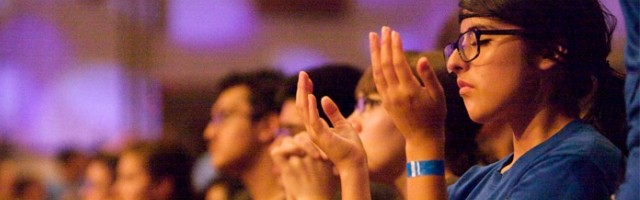 Una chica en oración en un encuentro de los grupos católicos de adolescentes LifeTeen
