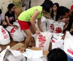 Jóvenes organizan paquetes de Cáritas Manila - la reconstrucción tras los desastres es muy lenta