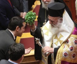 El Patriarca Ieronimos echa agua bendita sobre el ateo Tsipras, con el habitual efecto de alegría que suele causar este sacramental