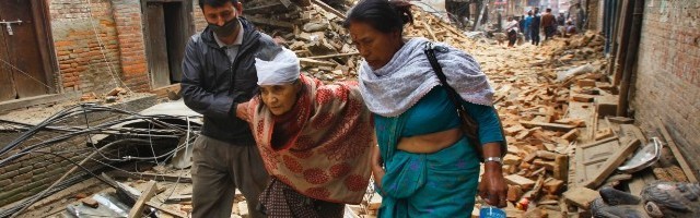 Dos nepalíes ayudan a una anciana herida en Bhaktapur, donde las réplicas del domingo agravaron los daños del terremoto del sábado