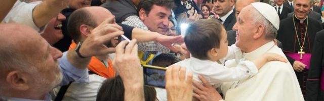 El Papa Francisco toma en brazos al niño de unos cursillistas españoles en el encuentro con esta ya veterana realidad eclesial y evangelizadora