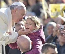 El Papa saluda a una niña en la audiencia del miércoles, que con el buen tiempo atrae a más gente