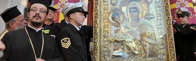 Clérigos y militares griegos veneran la Tricheroúsa de Monte Athos... la mano de metal a su pie recuerda el milagro de San Juan Damasceno