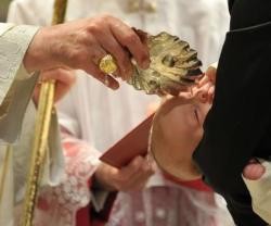 El Papa Francisco -véase el anillo en su mano- bautiza a un pequeño en la Capilla Sixtina