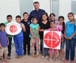 Niños de Irak con el logotipo de Ayuda a la Iglesia Necesitada, que mantiene decenas de proyectos allí y en Siria