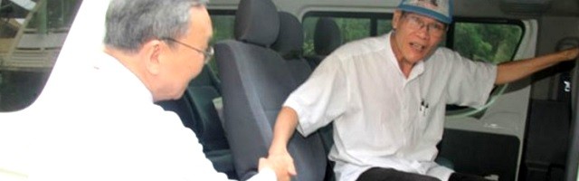 El arzobispo Tadeo, de Hue, ayuda a bajar al padre van Ly, debilitado tras 8 años de cárcel