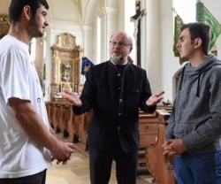 Peter Brummer, párroco católico de Tutzing, y los dos refugiados que se acogen a sagrado en su parroquia