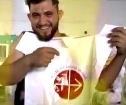 Un joven iraquí con el logo de Ayuda a la Iglesia Necesitada
