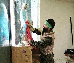 Un combatiente limpia una imagen de la Virgen tras tomar Qaraqosh